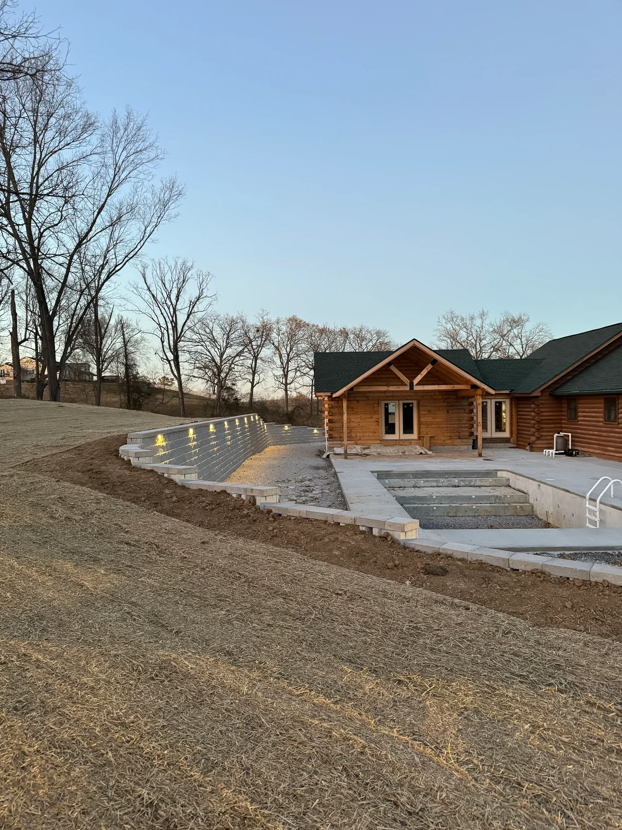 Retaining wall and outdoor concrete area beside a log home