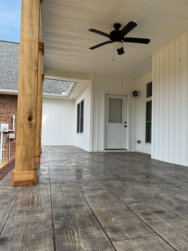Wood-grain patterned concrete beneath a covered porch with timber posts