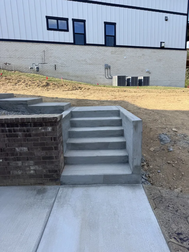 Concrete steps connecting a walkway through a block retaining wall